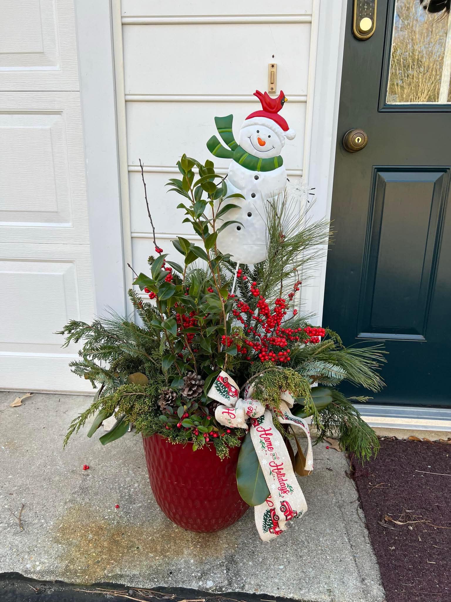 Custom outdoor holiday porch pot with berries, ribbon, and mixed greens